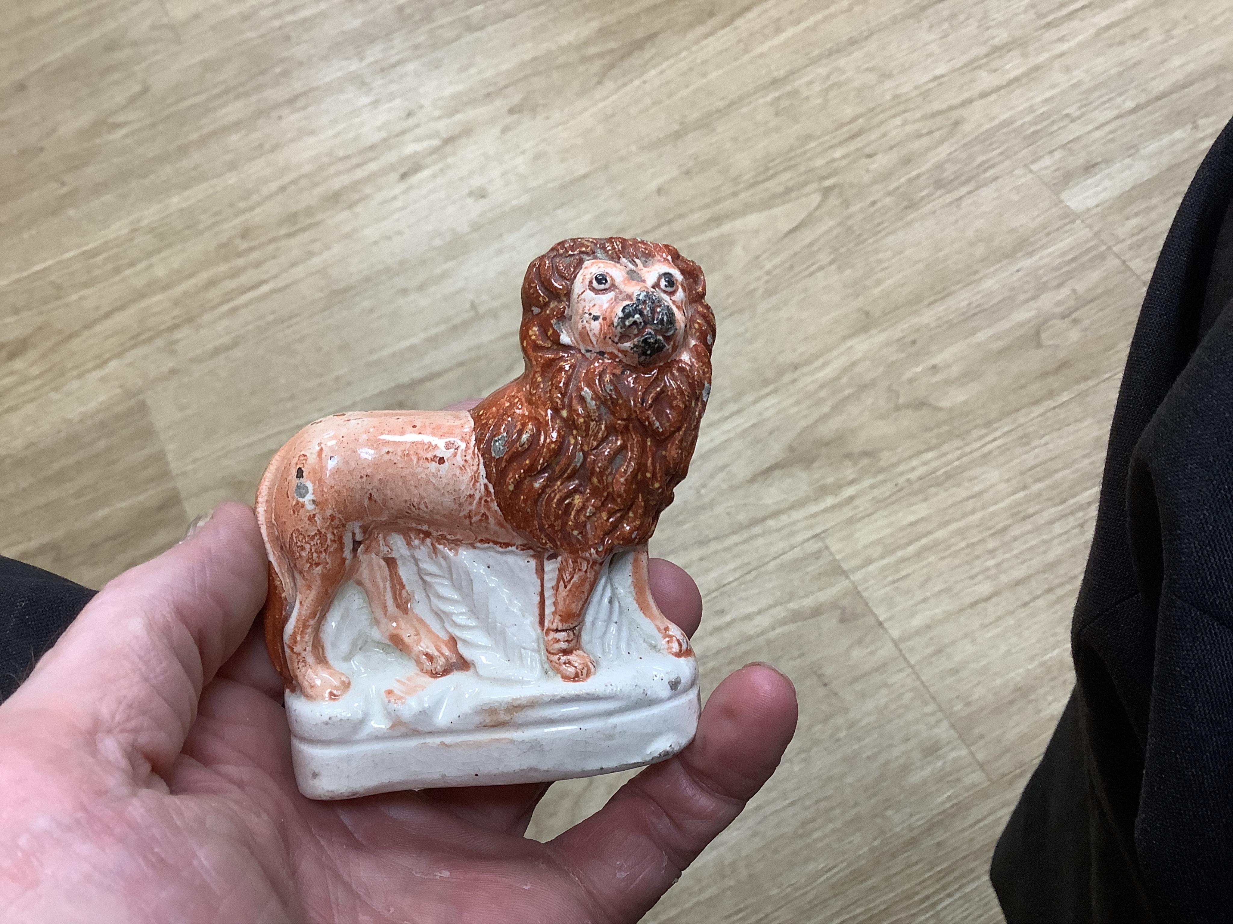 A rare Staffordshire Pearlware model of a recumbent lion, c.1810, and three Staffordshire pottery models of lions, mid 19th century, largest 11cm wide